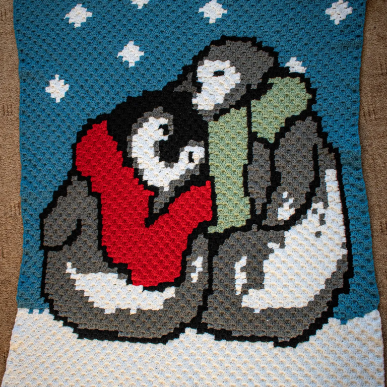 Crochet penguins hugging blanket