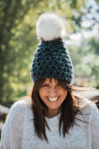 Happy woman green pom-pom beanie