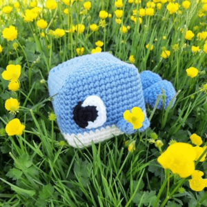 Blue crocheted whale in flowers