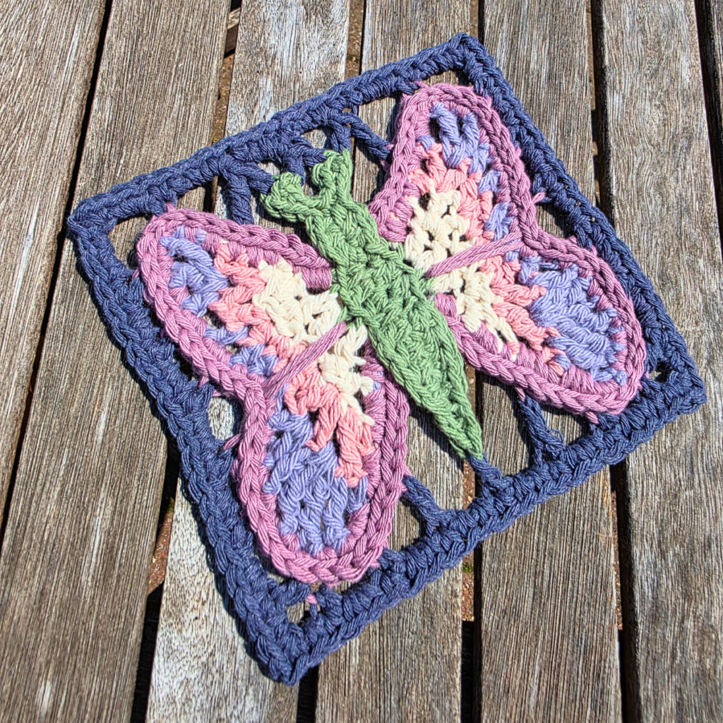 Crocheted butterfly on wooden table