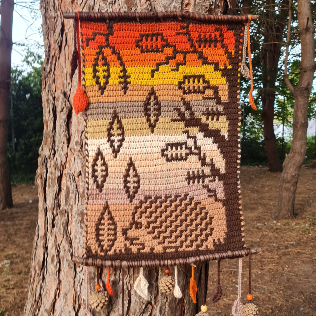 Crocheted autumn tapestry on tree
