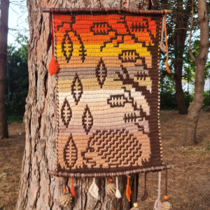 Crocheted autumn tapestry on tree